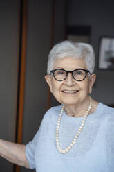 Smiling senior woman with white hair in apartment - JOSEF08534
