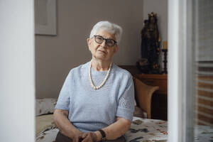 Einsame ältere Frau sitzt auf dem Bett im Schlafzimmer zu Hause - JOSEF08584