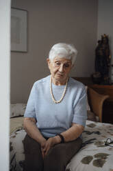 Worried senior woman sitting on bed at home - JOSEF08585