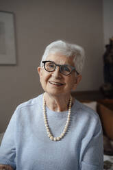 Happy senior woman wearing eyeglasses at home - JOSEF08586