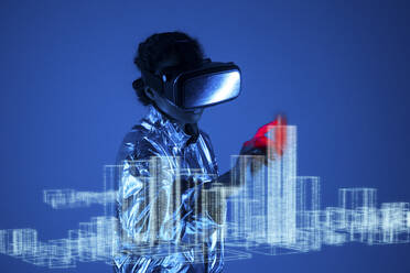 Woman wearing virtual reality simulator touching graph on screen against blue background - VPIF05777