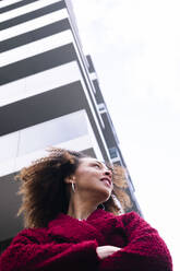 Afro-Frau mit verschränkten Armen vor einem Gebäude stehend - AMWF00288