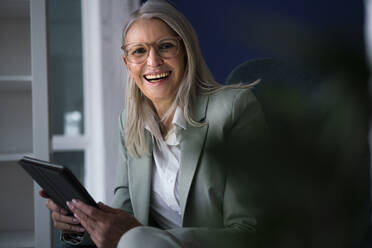 Ältere Geschäftsfrau hält lachend einen Tablet-PC - JOSEF08621