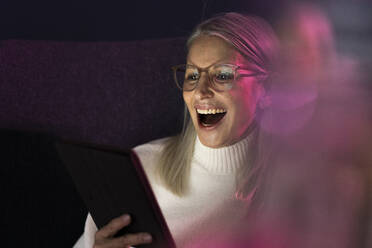 Lachende ältere Frau mit Blick auf einen Tablet-PC - JOSEF08666