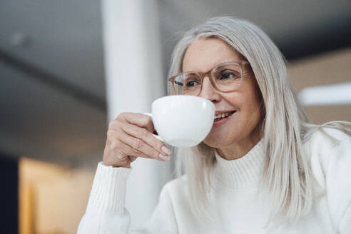 Lächelnde ältere Frau beim Kaffeetrinken - JOSEF08674