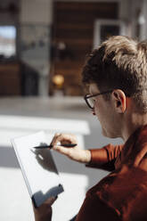 Geschäftsmann mit digitalisiertem Stift beim Schreiben auf einem Tablet-PC im Büro - JOSEF08712