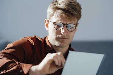 Geschäftsmann mit Brille bei der Arbeit am Tablet-PC im Büro - JOSEF08723