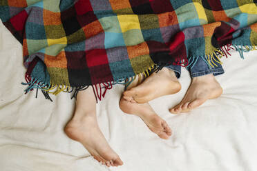 Feet of couple lying on bed - OGF01161