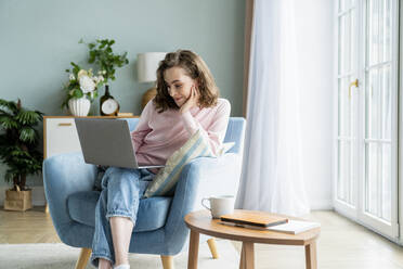 Businesswoman working on laptop at home - VPIF05860