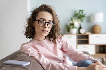 Young woman wearing eyeglasses in living room - VPIF05913