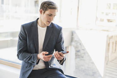 Geschäftsmann benutzt Smartphone im Büro - UUF25770