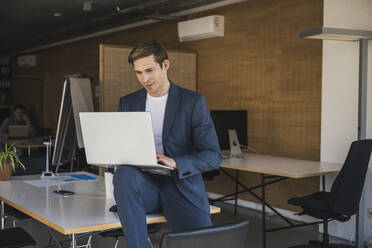 Geschäftsmann mit Laptop im Büro - UUF25776