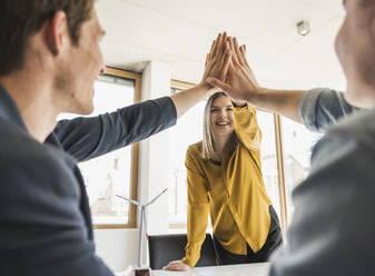 Happy business team high fiving in office - UUF25819