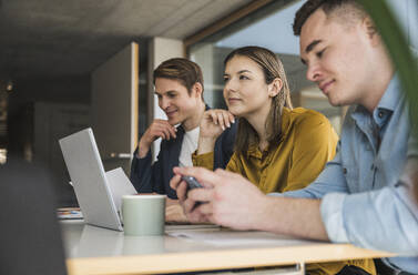 Businesswoman with colleagues daydreaming in office - UUF25824