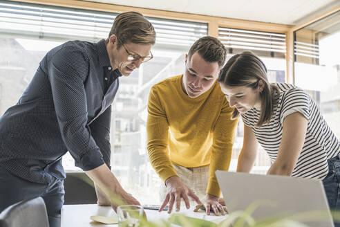 Geschäftsleute, die sich im Büro treffen und Dokumente besprechen - UUF25851