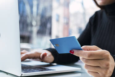 Businesswoman holding credit card using laptop - PNAF03776