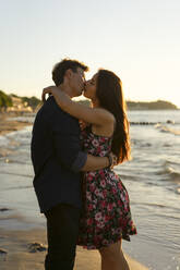 Affectionate couple kissing each other at beach - SSGF00772