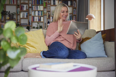 Glückliche Frau winkt bei Videoanruf über Tablet-PC zu Hause - RBF08878