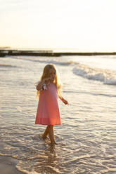 Cute girl with blond hair walking at beach - SSGF00811