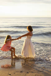 Glückliche Tochter spielt mit Mutter am Strand - SSGF00814