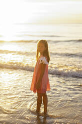 Girl standing at beach on sunny day - SSGF00819