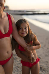 Glückliche Tochter hält Hand der Mutter am Strand - SSGF00827