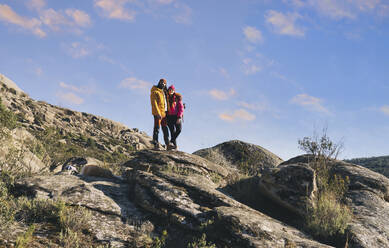 Paar steht zusammen auf einem Felsen an einem sonnigen Tag - JCCMF06121