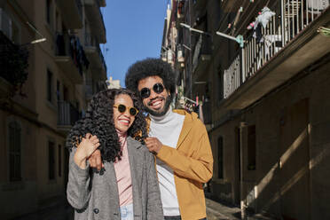 Glückliches Paar mit Sonnenbrille an einem sonnigen Tag in der Stadt - MMPF00005