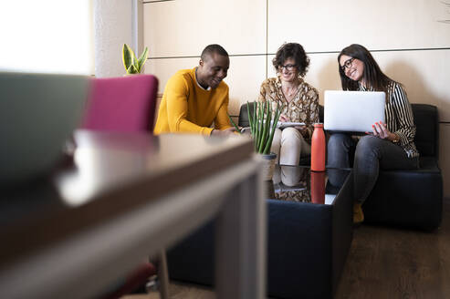 Arbeitsgruppe, die in einem Büro mit einem Laptop ein Projekt vorbereitet. - CAVF96250