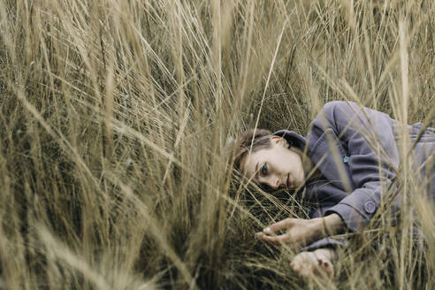 Rothaarige russische Frau im Gras liegend an einem Herbsttag - CAVF96264