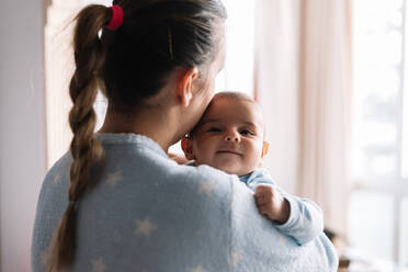 Smiling baby in her mother's arms. - CAVF96279