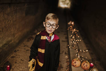 Smiling boy wearing costume standing in tunnel - GMLF01298