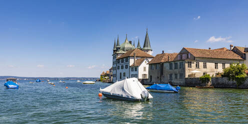 Schweiz, Thurgau, Steckborn, Schrumpfverpackte Boote schwimmen in der Nähe des Bodenseeufers mit Stadthäusern im Hintergrund - WDF06907