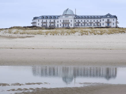 Deutschland, Niedersachsen, Juist, Sandstrand an der Küste mit Hotel im Hintergrund - WIF04503