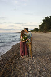 Man kissing on woman's forehead at beach - SSGF00834