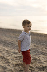 Cute baby boy standing at beach - SSGF00838