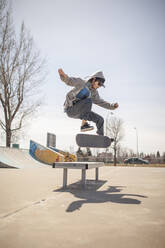 Young skateboard enthusiast doing a kickflip - CAVF96310