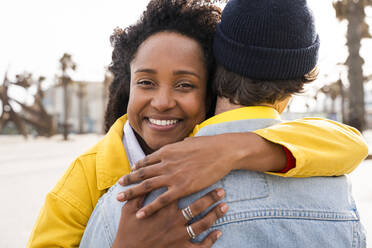 Happy woman with Afro hairstyle hugging man - OIPF01638