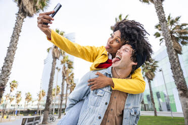 Paar streckt Zungen heraus und macht ein Selfie mit dem Smartphone - OIPF01648