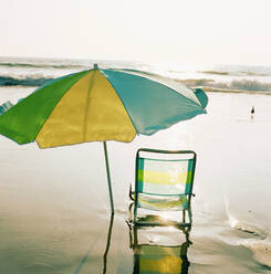 Beach chair and umbrella on beach at sunset - TETF01629