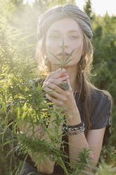 Frau in der Cannabis-Pflanze, Mädchen stehend mit Marihuana oder Saum - CAVF96314
