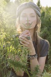 Woman in the Cannabis plant, Girl standing with Marijuana or Hem - CAVF96314