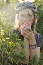 Frau in der Cannabis-Pflanze, Mädchen stehend mit Marihuana oder Saum - CAVF96316