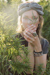 Woman in the Cannabis plant, Girl standing with Marijuana or Hem - CAVF96316