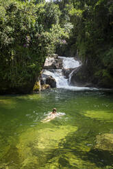 Schöner Blick auf Frau schwimmen auf grünen Pool auf Regenwald Wasserfall - CAVF96342