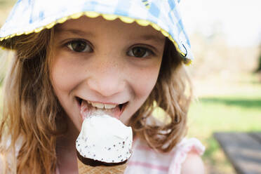 Nahaufnahme eines Mädchens mit Sommersprossen, das Eiscreme isst - CAVF96424