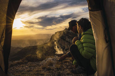 Blick aus dem Zelt eines jungen Paares beim Camping in den Bergen. - CAVF96434