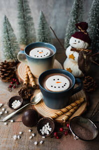 Tassen mit heißem Kakao und Marshmallows, umgeben von winterlichen Dingen. - CAVF96490