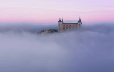 Antike Burg in Nebel gehüllt in bunten lila Sonnenaufgang - CAVF96552