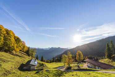 Germany, Bavaria, Sun shining over secluded huts in Chiemgau Alps - FOF13124